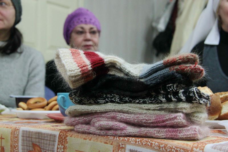 Одна из новых добровольцев принесла для подопечных Православной службы милосердия вязанные носочки, которые стопкой лежали на столе, вызывая доброжелательные улыбки и поднимая настроение